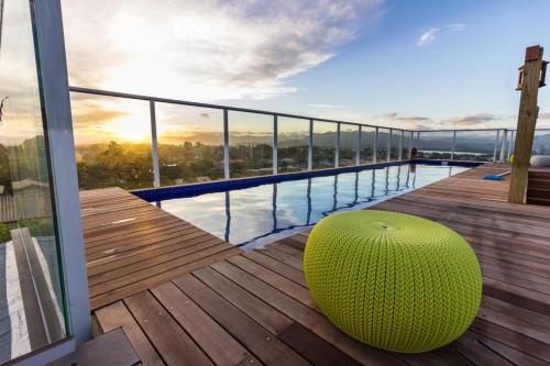 a large green ottoman sitting on a deck on a building at Pousada Las Piedras in Praia do Rosa