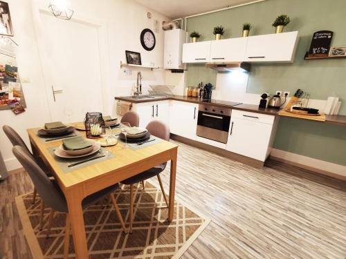 une cuisine et une salle à manger avec une table et des chaises en bois dans l'établissement Au Bretzel Doré - Centre Historique, à Colmar