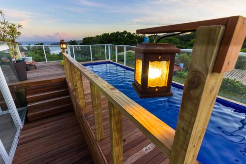 a deck with a lantern and a swimming pool at Pousada Las Piedras in Praia do Rosa