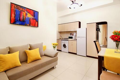 a living room with a couch and a kitchen at Apartments in Alley Residence in Yerevan