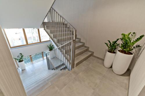 a staircase with potted plants in a room at BlueApart Verano Residence in Jurata