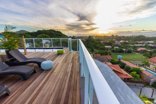 a balcony with chairs and a view of a city at Pousada Las Piedras in Praia do Rosa