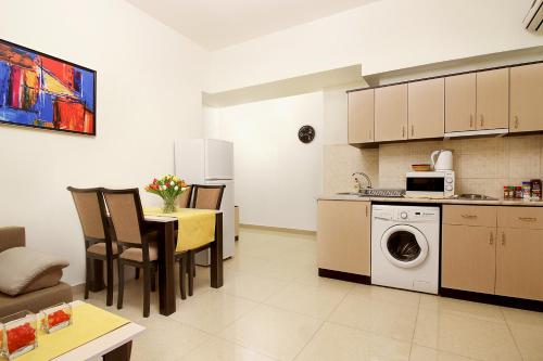 a kitchen and living room with a table and a microwave at Apartments in Alley Residence in Yerevan
