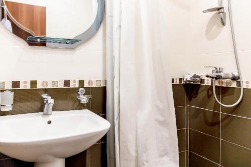 a bathroom with a sink and a mirror and a shower at Apartments in Alley Residence in Yerevan