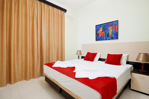 a bedroom with a large bed with red pillows at Apartments in Alley Residence in Yerevan