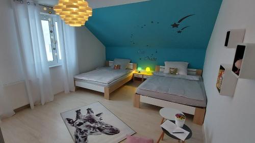 een kleine slaapkamer met 2 bedden en een giraf muurschildering bij Fewo Diego in Winterberg
