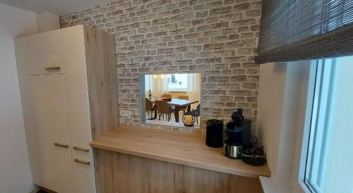 a kitchen with a mirror on a brick wall at Fewo Diego in Winterberg