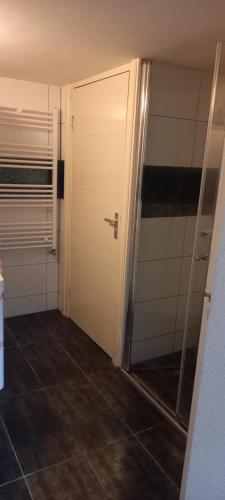 um quarto com uma porta e um piso de azulejo em 74 Pijnboomstraat em Haia
