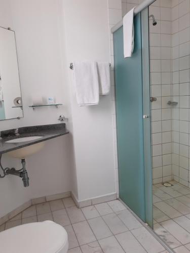 a bathroom with a shower and a toilet and a sink at Rede Andrade Guaíra in Curitiba