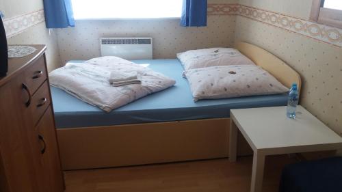 łóżko z 2 poduszkami i stołem w pokoju w obiekcie limba w Jastarni