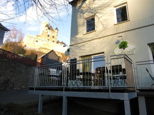 a building with a fence next to a building with a castle at Gästehaus "Auszeit" in Burgschwalbach