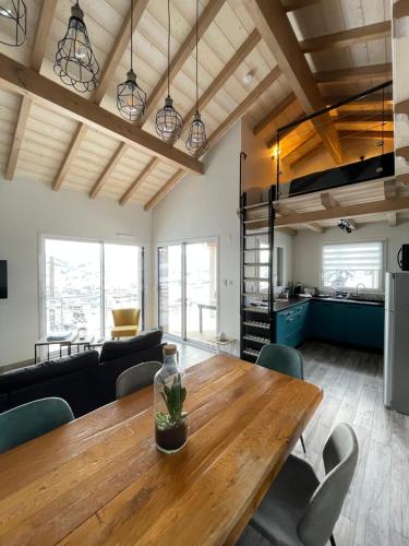 uma sala de jantar e sala de estar com uma mesa de madeira em le bleu du lac Sauna et Spa em Gérardmer