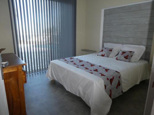 a bedroom with a bed and a large window at CHAMBRE NAMIBIE, villa belle vue 