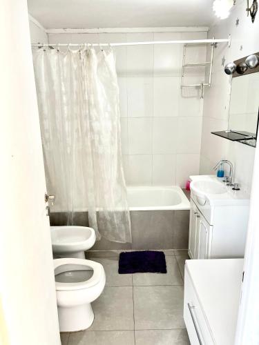 a bathroom with a toilet and a tub and a sink at Departamento Alassio in Tigre