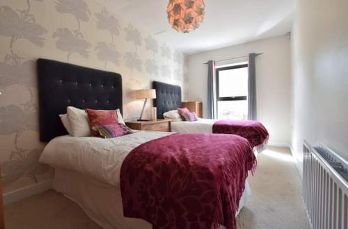 a bedroom with two beds and a chandelier at Fantastic sea view apartment! in Portstewart