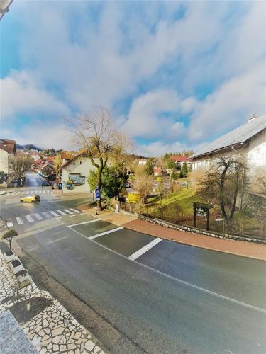an empty street with a yellow car on the road at Sobe "Ela" in Fužine