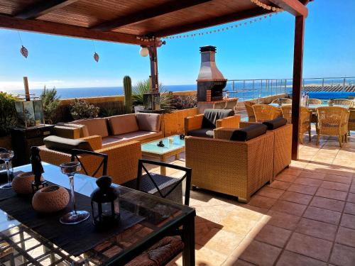 a patio with furniture and a view of the ocean at Luxury 5 star Villa Violetta with amazing sea view, jacuzzi and heated pool in San Agustin