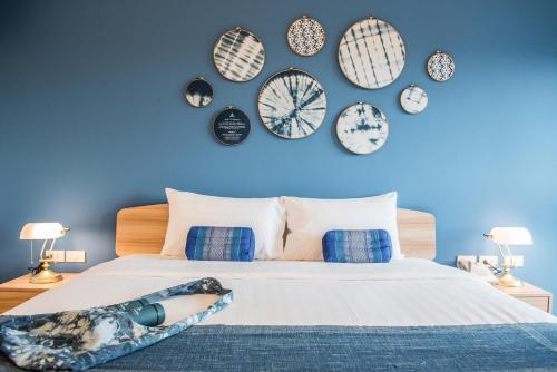 a woman laying on a bed with clocks on the wall at DeeProm Pattaya Hotel in Pattaya Central