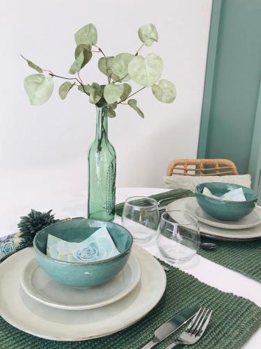 une table avec deux bols et un vase avec des fleurs dans l'établissement Cocon douillet face à la mer de Cagnes sur mer, à Cagnes-sur-Mer