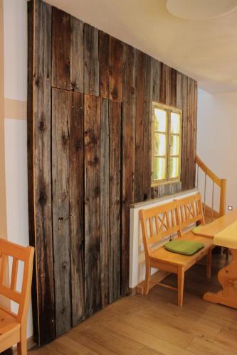 a room with a wooden wall with a table and chairs at Wirtsberg Pension & Cafe in Günzenhausen