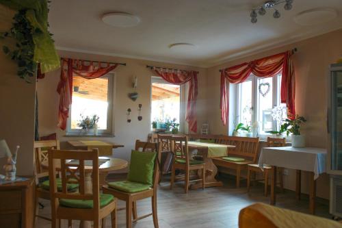 a restaurant with tables and chairs and windows at Wirtsberg Pension & Cafe in Günzenhausen