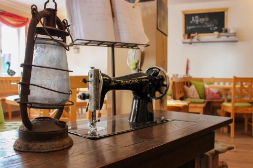 una vieja máquina de coser sentada en una mesa en Wirtsberg Pension & Cafe 
