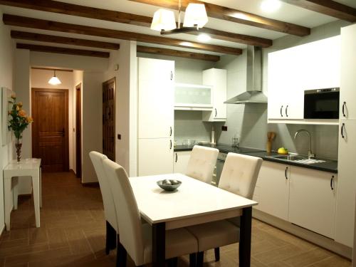 a kitchen with a table and chairs in a room at Apartamentos Rurales El Palomar in Villar del Humo