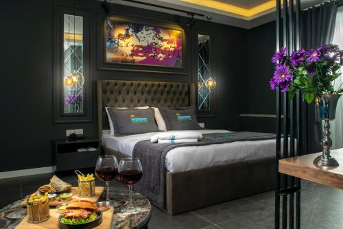 a bedroom with a bed and two glasses of wine at La Cielo Hotel Bostancı in Istanbul