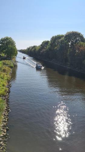 a river with two boats in it with trees at Marianne in Emden