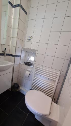 bagno bianco con servizi igienici e lavandino di Marianne a Emden