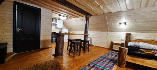 a room with a black door and a table and chairs at Студіо Номер 5 Садиба У Ані in Synevyrsʼka Polyana