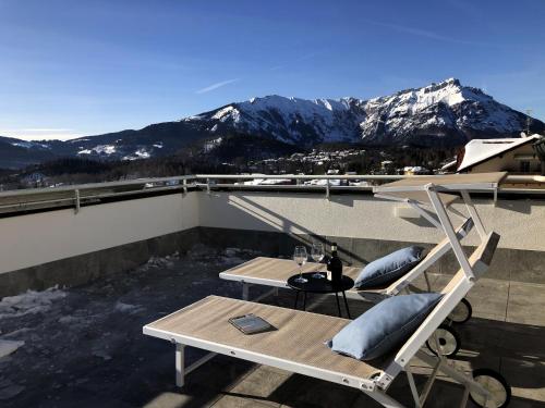 a balcony with a table and chairs and mountains at Residence Aurora in Lavarone