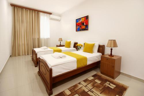 een slaapkamer met 2 bedden met gele en witte lakens bij Apartments in Homey Residence in Jerevan