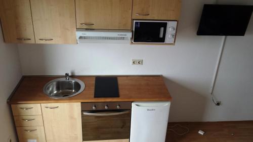 a small kitchen with a sink and a microwave at Apartments Adriatic 3 in Selce
