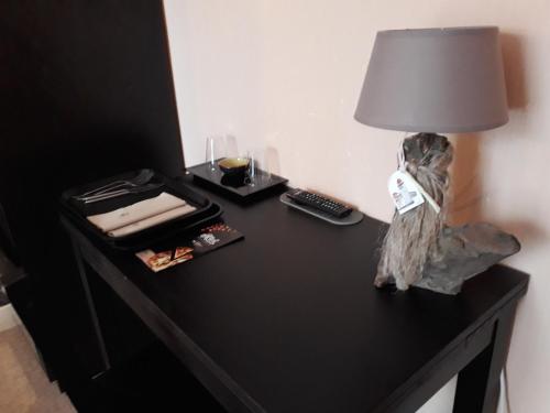 a black table with a lamp on top of it at Hôtel Ambroise in Uzerche