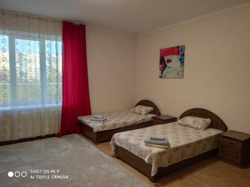 a bedroom with two beds and a window at Apartments "Domovik" Івана Парканія 2а кв 19 in Mukacheve