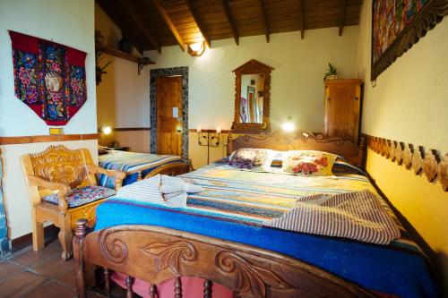 a bedroom with two beds and a chair at Hotel La Casa del Mundo in Jaibalito