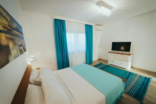a hotel room with a bed and a television at Pensiunea Briza Marii Jurilovca in Jurilovca