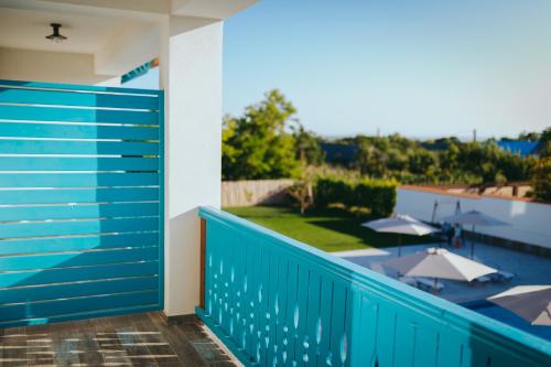 a balcony with a blue fence and a swimming pool at Pensiunea Briza Marii Jurilovca in Jurilovca