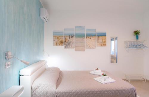 a bedroom with a bed and a painting of a beach at South Valley in Agrigento