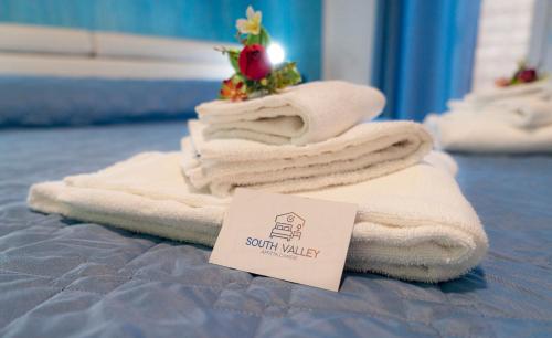 una pila de toallas sentadas encima de una cama en South Valley, en Agrigento
