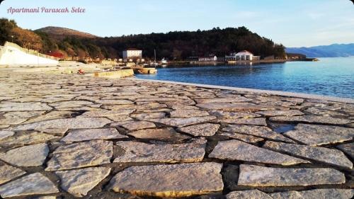 an image of a stone beach next to a body of water at Apartments Adriatic 3 in Selce