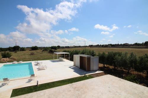 a swimming pool on a patio next to a field at Casa Sbrizza in Rosolini