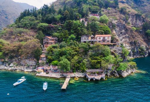 an island with houses on a hill in the water at Hotel La Casa del Mundo in Jaibalito