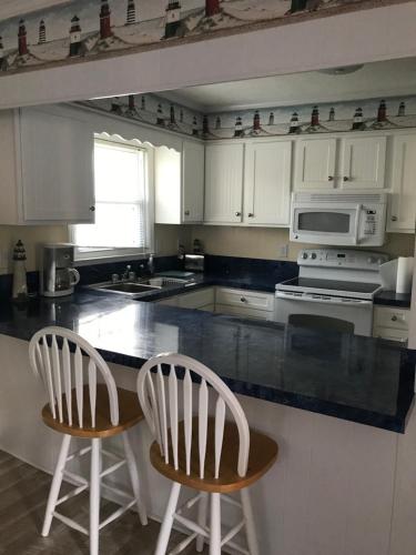 a kitchen with two white chairs and a counter top at Beach Breeze 1, short walk to Atlantic Ocean, pet friendly, very quiet & family friendly in Myrtle Beach