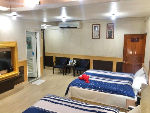 a hotel room with two beds and a television at TREE HOUSE in Pingtung County