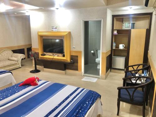 a bedroom with a bed and a tv and a bathroom at TREE HOUSE in Pingtung County