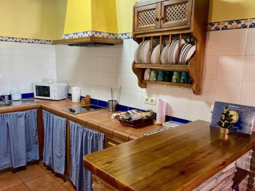 uma cozinha com um balcão de madeira num quarto em Casa Rural El Zaguán em Jimena de la Frontera