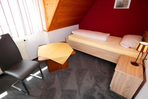 a small room with a bed and a desk and a chair at Ferienwohnung im Steinachtal in Nagold