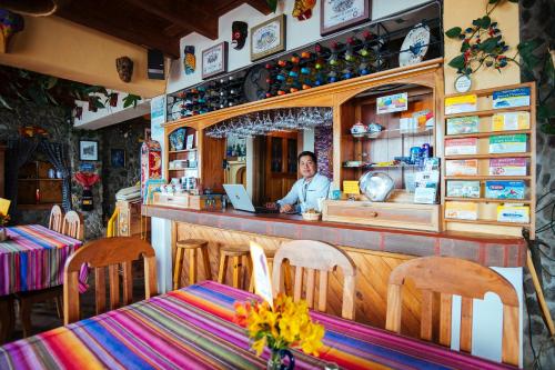 a man sitting at a bar with a laptop at Hotel La Casa del Mundo in Jaibalito